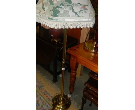 A brassed standard lamp with bird decorated shade.