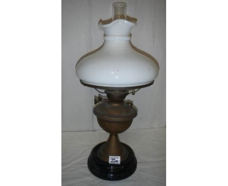 A brass oil lamp on pot base and complete with mushroom shade.