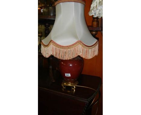 An urn shaped table lamp with shade.