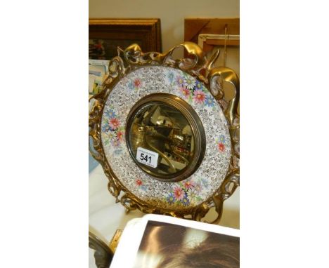 A brass and ceramic circular mirror.