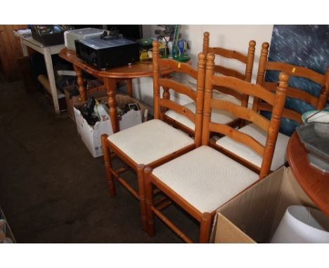 A pine extending dining table with a set of four ladder back chairs