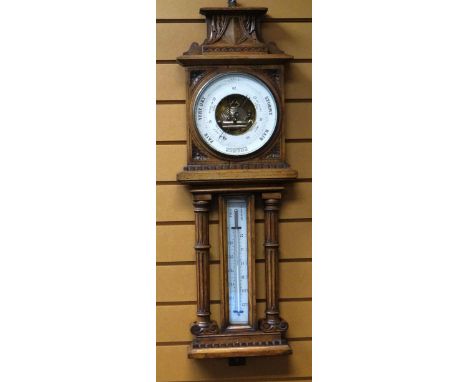 A LATE NINETEENTH CENTURY OAK ANEROID BAROMETER of architectural form and with carved detail, 84cms high