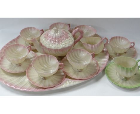 A BELLEEK TEA SERVICE IN THE NEPTUNE PATTERN comprising tray, teapot, six cups and saucers, sugar basin and cream jug, all of