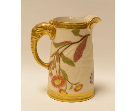 A ROYAL WORCESTER JUG WITH ELEPHANT HANDLE in blush ivory, gilding and with painted flowers, 13cms high