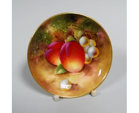 A SMALL ROYAL WORCESTER FRUIT PAINTED DISH of circular form and painted with peaches and green grapes by Frank Roberts, signe
