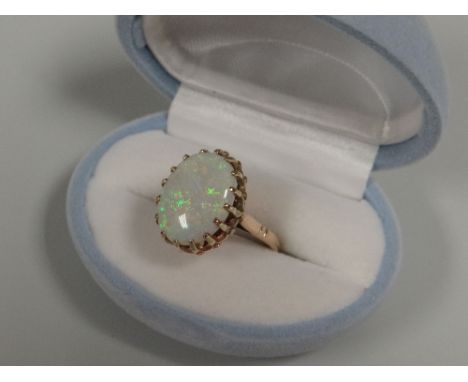 A 9CT GOLD OPAL RING, the opal measuring 14mms long in a sixteen claw setting, 4.54gms