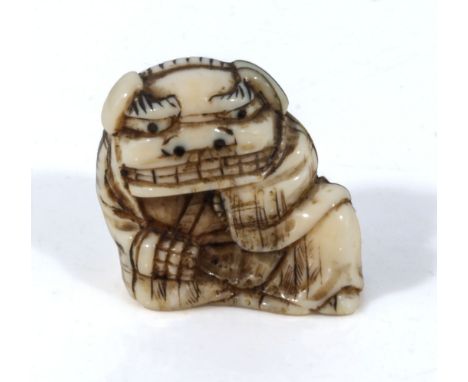 An antique Japanese ivory netsuke meiji period, depicting a boy dressed in a dragon outfit, with horn inlayed eyes. signed