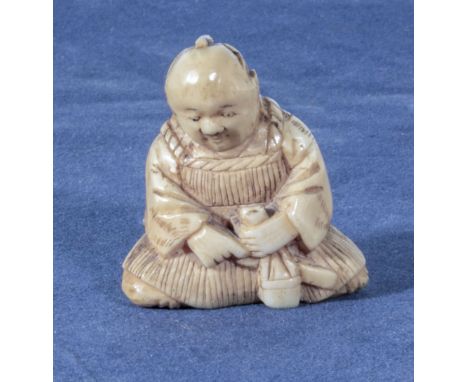 An antique netsuke of a seated man, 1.25"