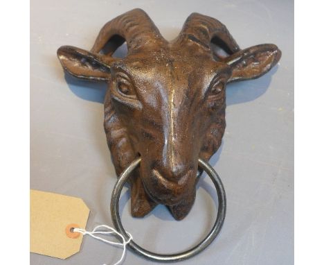 A cast iron door knocker in the form of a ram's head. 