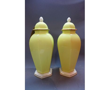 A pair of Royal Worcester hexagonal baluster vases with gilt bordered on a yellow ground (with lid), H:43cm