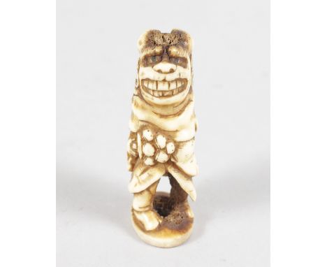 A STAG ANTLER GROTESQUE FIGURE NETSUKE.  6cms high.