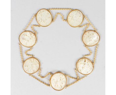 A SUPERB GOLD BRACELET set with SEVEN CARVED CHINESE MOTHER-OF-PEARL OVALS.