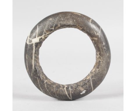 A ROMAN GREY VEINED STONE BANGLE.