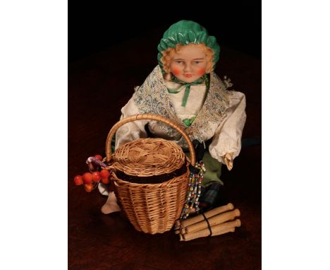 An English bisque shoulder head doll, modelled as a Gypsy, the bisque head with painted features including blue intaglio eyes