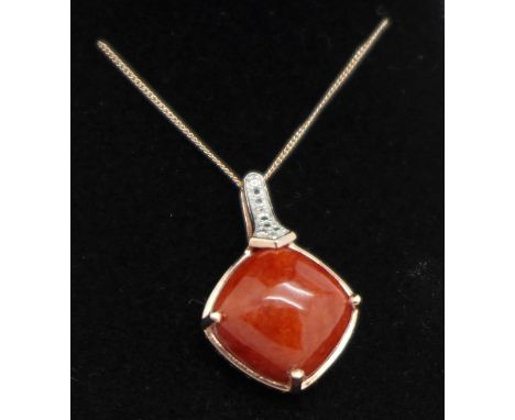 A silver gilt, red jade and diamond pendant