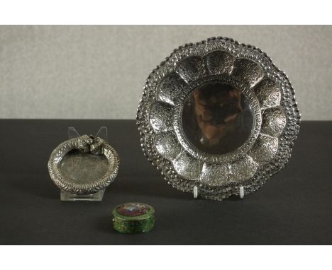 Three Oriental silver and white metal pieces, including a repousse design floral form dish on three button feet, an Egyptian 