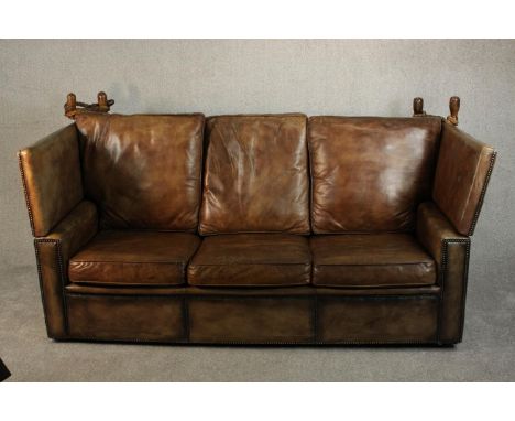 A Knole style contemporary brown leather sofa, with turned stained beech finials and studded edges. H.109 W.250 D.95cm. 