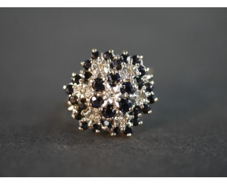 A sapphire and diamond 9 carat yellow and white gold cluster ring, set with seven round eight cut diamonds with a combined ap