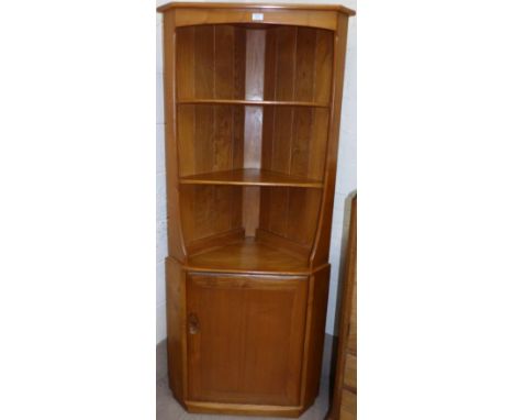 An Ercol light elm corner cupboard