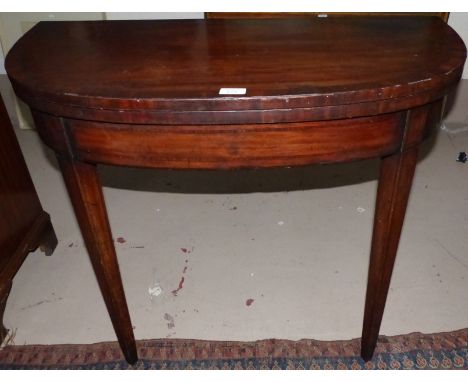 A late Georgian crossbanded 'D' fronted fold-over card table on tapering legs
