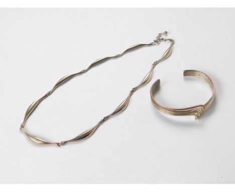 SILVER BANGLE ETC. A silver torque bangle with twist front & a white metal scalloped necklace.  Please note that all items in
