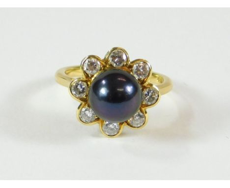 BOODLES RING. A Boodles 18ct. gold dress ring, set a large Tahitian black pearl within a diamond border. Fully stamped. Size 