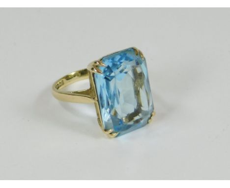 DRESS RING. A modern 9ct. gold dress ring, set a faceted blue stone (possibly blue topaz). Size K.  Please note that all item