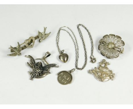 SILVER BROOCHES ETC. A Victorian silver bird bar brooch, a small silver heart locket on chain, a silver filigree brooch & thr