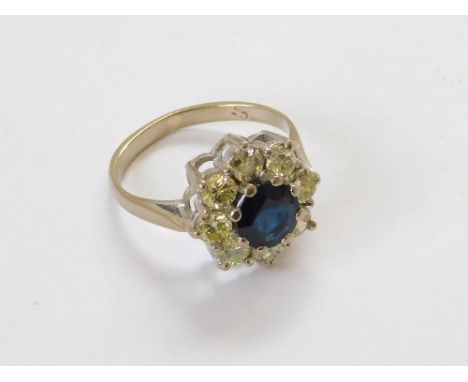 SAPPHIRE RING. An 18ct. white gold sapphire & diamond cluster ring. Each diamond of approx. 0.20ct. spread. Setting measures 