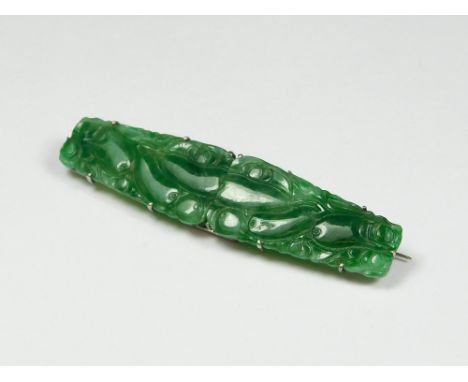 JADE CLIPS. An Art Deco green jade double clip brooch set in unmarked white metal. Width 6cm.  Please note that all items in 