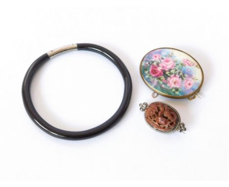 COSTUME JEWELLERY. A brass mounted, hand painted porcelain brooch, width 4.6cm. Also, a Chinese carved & pierced brooch & a c