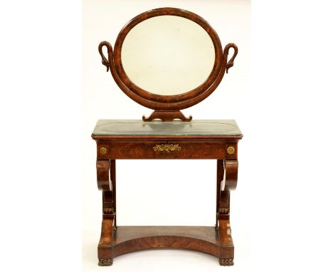 A French Empire mahogany dressing table, in highly figured veneers, the oval mirror supported on a U-shaped bracket terminati