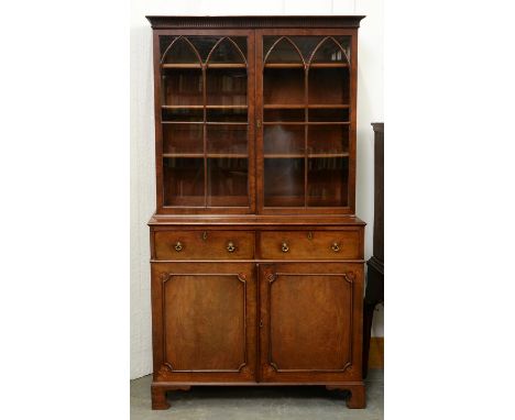 A George III mahogany bookcase-press, with fluted cavetto cornice and fitted with adjustable shelves enclosed by doors with t