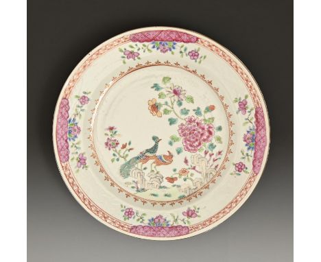 A Chinese export porcelain famille rose plate, c1780, painted with peafowl and peony, in red and gilt spearhead cavetto, 23.5