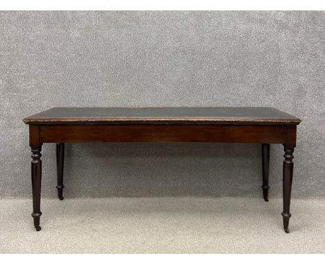 A 19th century mahogany console table having a rectangular tooled and gilt green leather moulded top raised on four turned ba