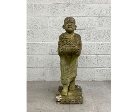 A vintage reconstituted stone stylised Buddhist monk garden statue raised on a square plinth base. H.104cm