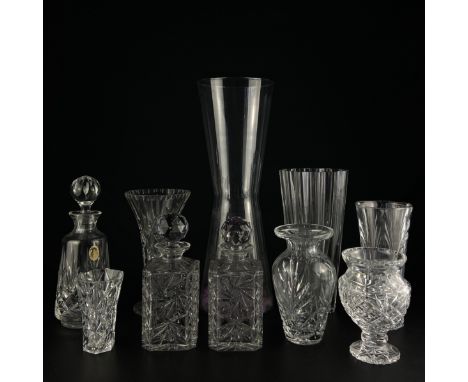 A mixed collection of cut glass a lead crystal to include three decanters with stoppers, six vases and a tumbler. H.50cm