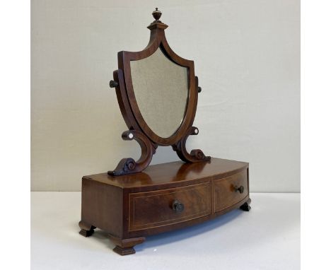 A 19th century mahogany toilet mirror having a shield shaped plate in a crossbanded frame with a cup and cover finial and a s