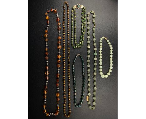 A collection of six necklaces to include a Chinese chatoyant tiger's eye beaded necklace with a gold plated silver filigree c