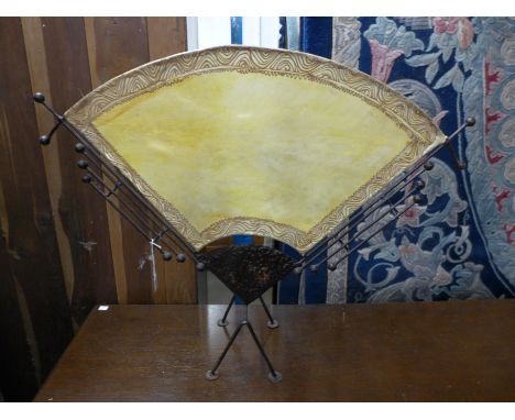 A 1920-30's Chinese style black painted metal and pigskin fire screen