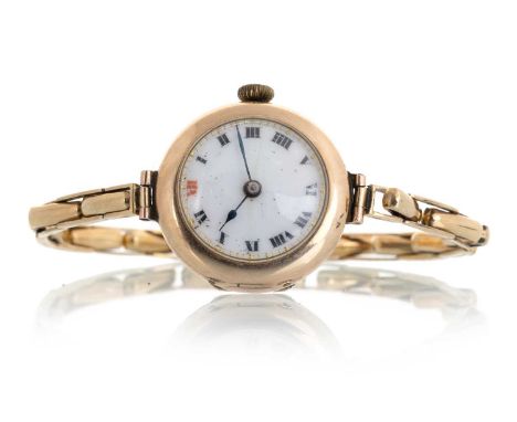 NINE CARAT GOLD MANUAL WIND WRIST WATCH, the round dial with numerals in black and a red 12, the case and expanding bracelet 