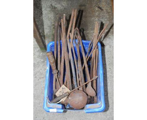 A tub of blacksmith's tools including two metal ladles.