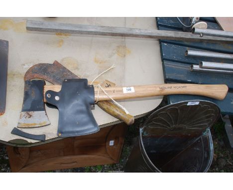 A hedging hacker and a small Hickory handled axe with axe head protector.