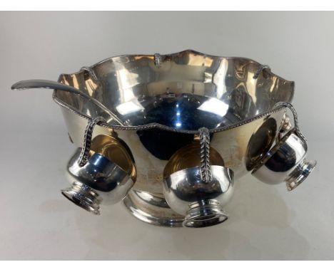 A large silver on copper punch bowl, with scalloped rim and lion mask ring handles, together with a set of six silver plated 
