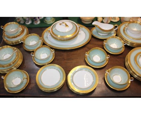 An Aynsley porcelain part dinner service, with a pale green band and gilt borders, comprising oval platter, tureen and cover,
