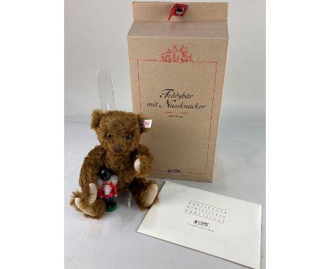 A Steiff limited edition teddy bear, holding a nutcracker, in russet mohair, 853/3000, with button in ear and certificate in 