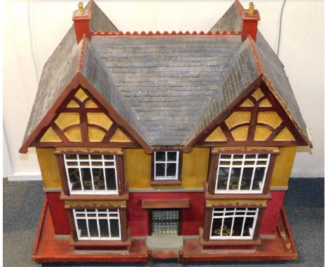 A vintage mid 20thC wooden doll's house, double bay and forecourt, with a triple roof, rear entry, opening to reveal four roo