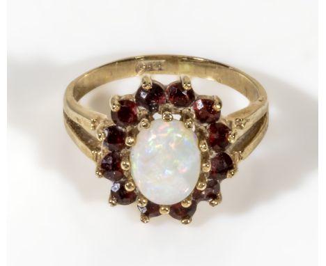 A ladys 9ct gold ring set with garnets and an opal, UK size L