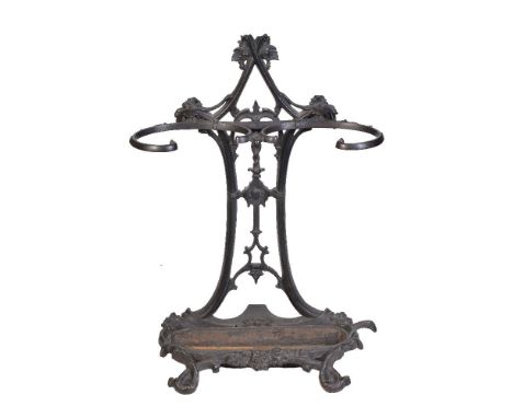 A Victorian cast iron walking stick stand, with openwork foliate cast backplate and scrolled retaining bars; the oval section