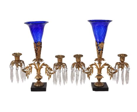 A pair of Regency gilt bronze and glass lustre hung twin light candelabra, circa 1815, each with possibly later flared blue g